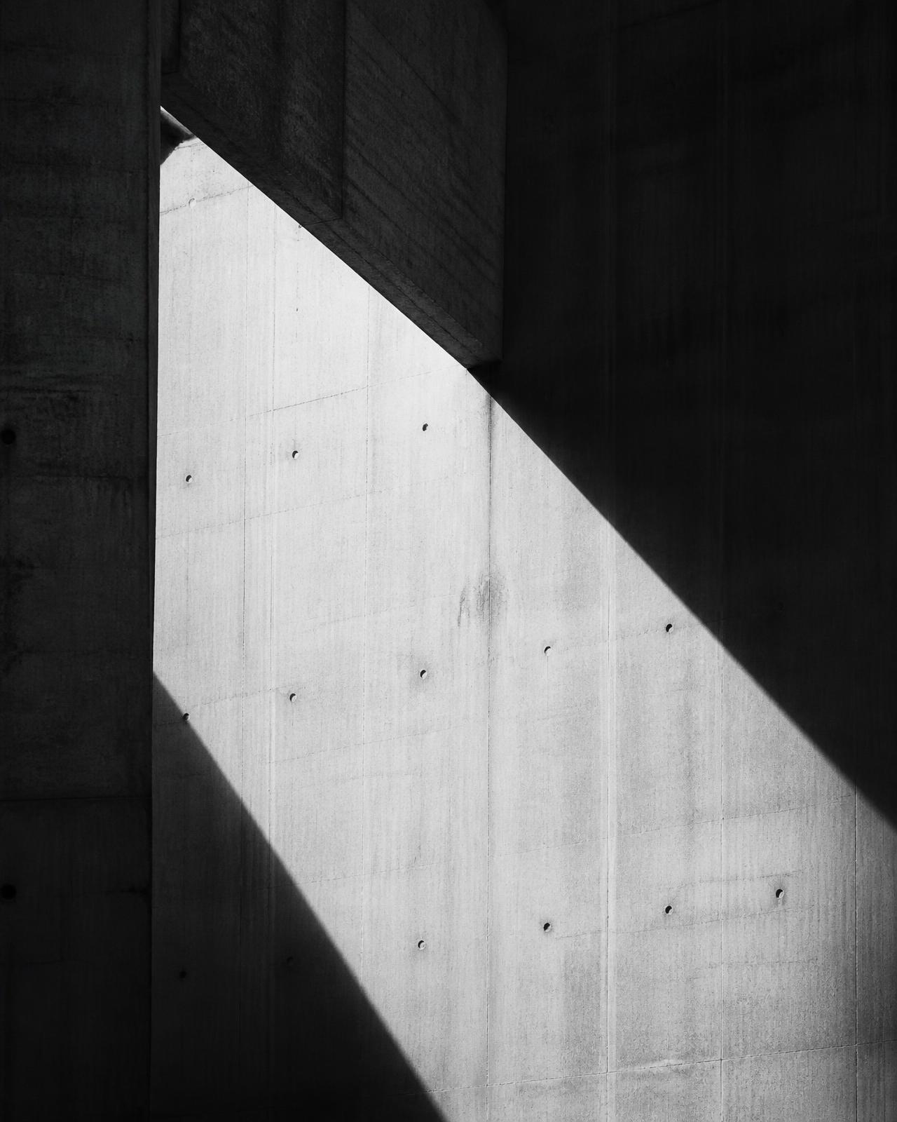 Concrete wall cut by a hard diagonal shadow